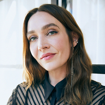 A professional image of SAMAG Committee Member Katie Winten, who has brown hair and is wearing a striped shirt.